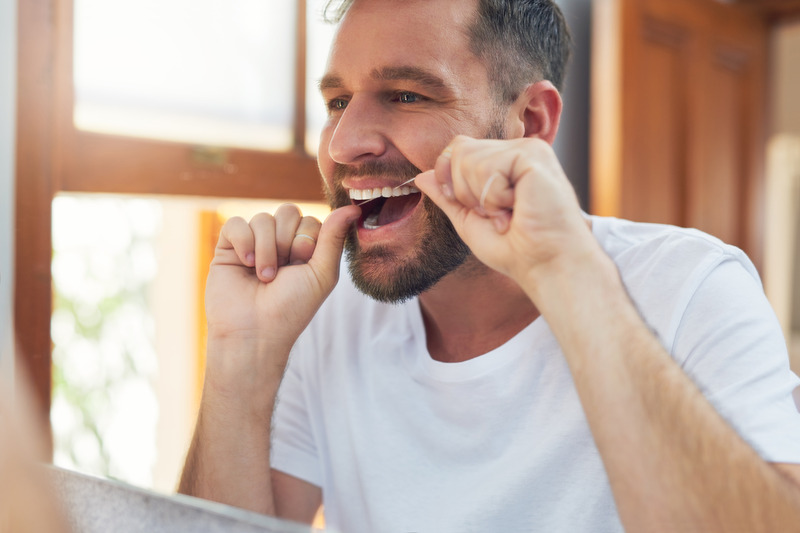 Nu Smile patient flossing in the mirror